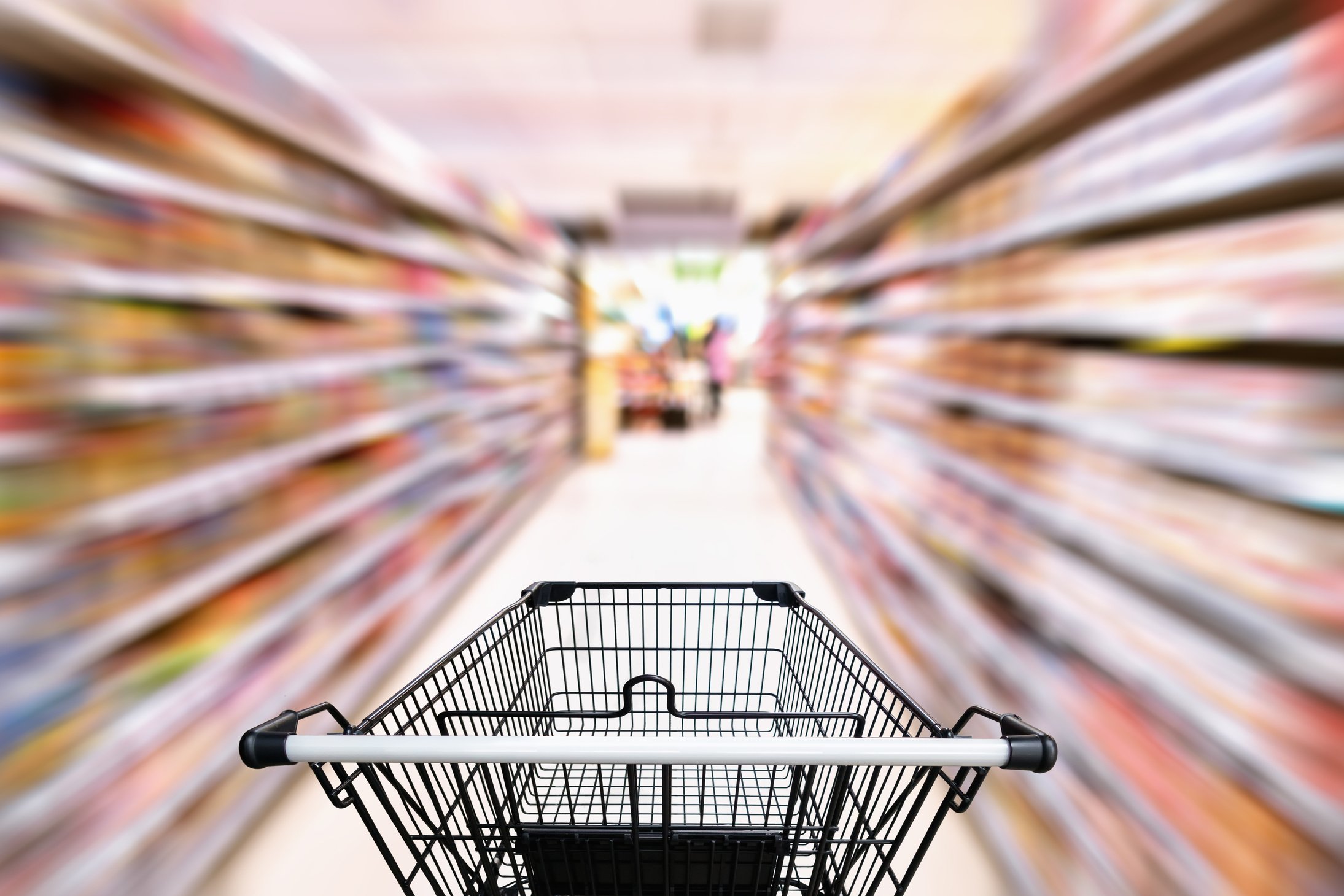 Shopping trolley in department store with consumer goods product on shelf background, Abstract motion blurred concept